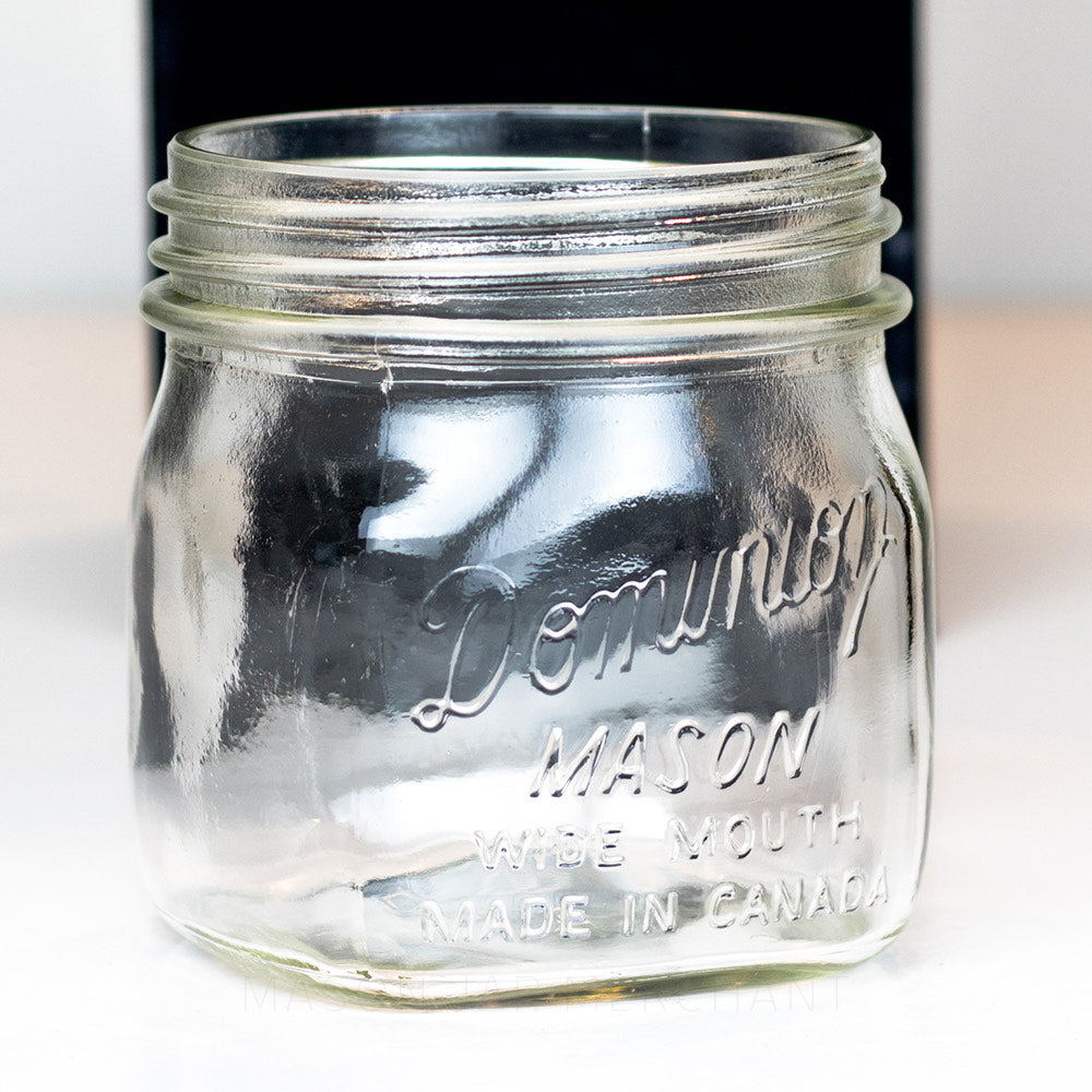 close up of a Dominion wide mouth glass mason jar pint on a white background