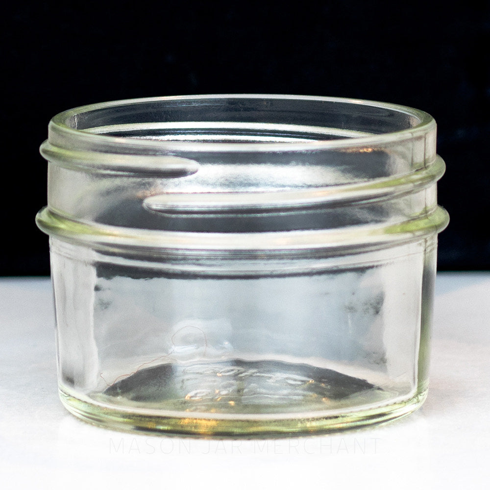 A close up of a Adorable 2 oz. regular mouth mason jar with straight sides on a white background, perfect for spices!
