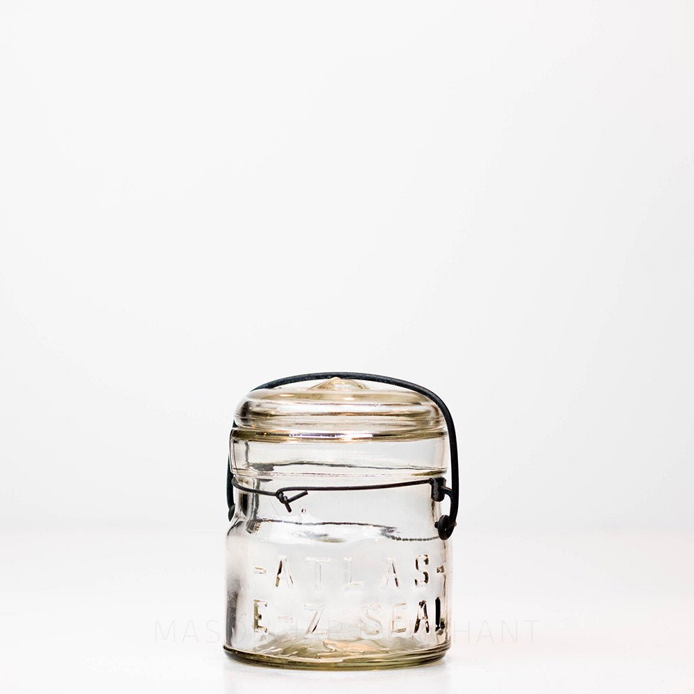 Vintage 1920s wire bail Atlas E-Z seal half pint mason jar against a white background