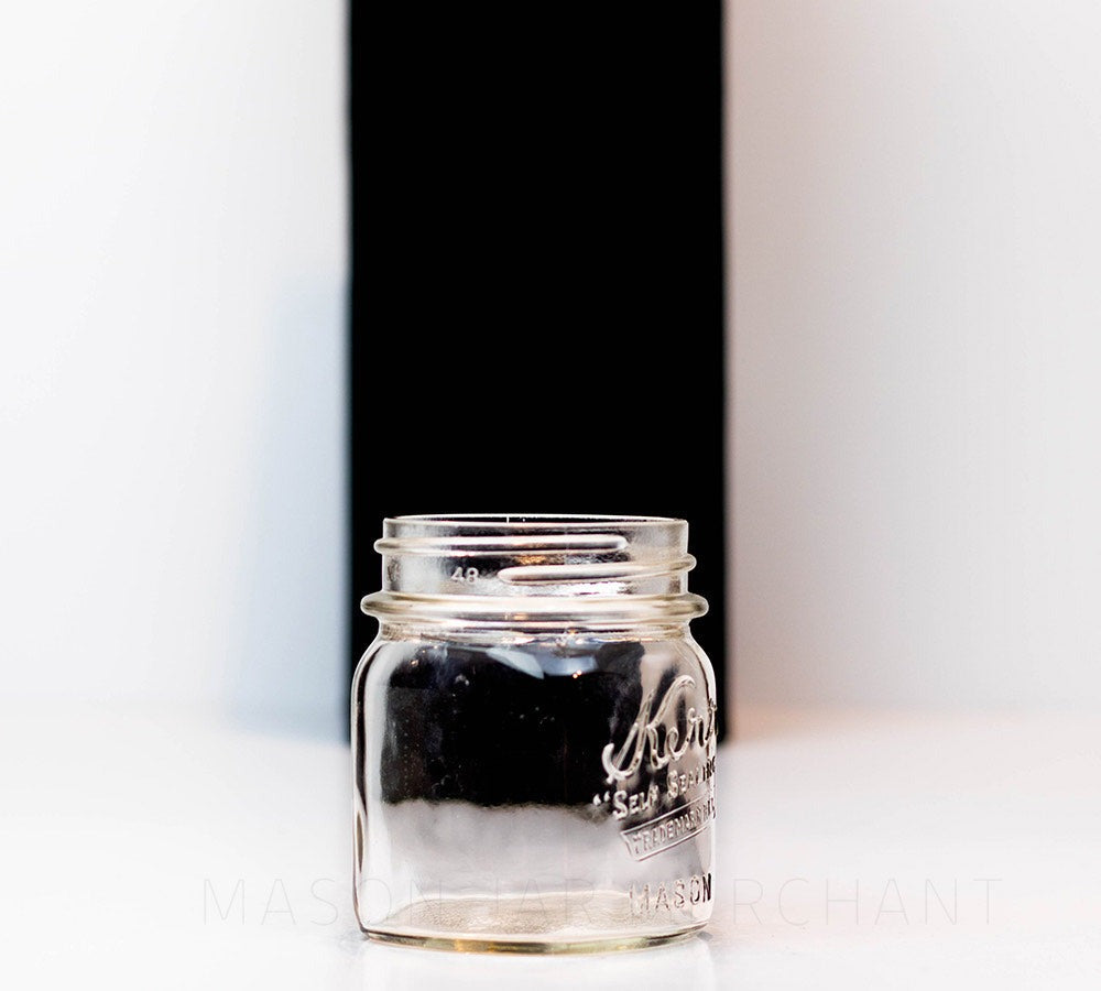 Close up of a Regular mouth half-pint mason jar with Kerr self-sealing logo, against a white background