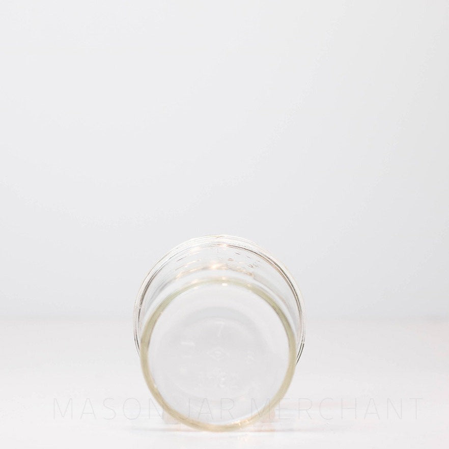 Bottom of a Regular mouth half pint mason jar with straight sides against a white background