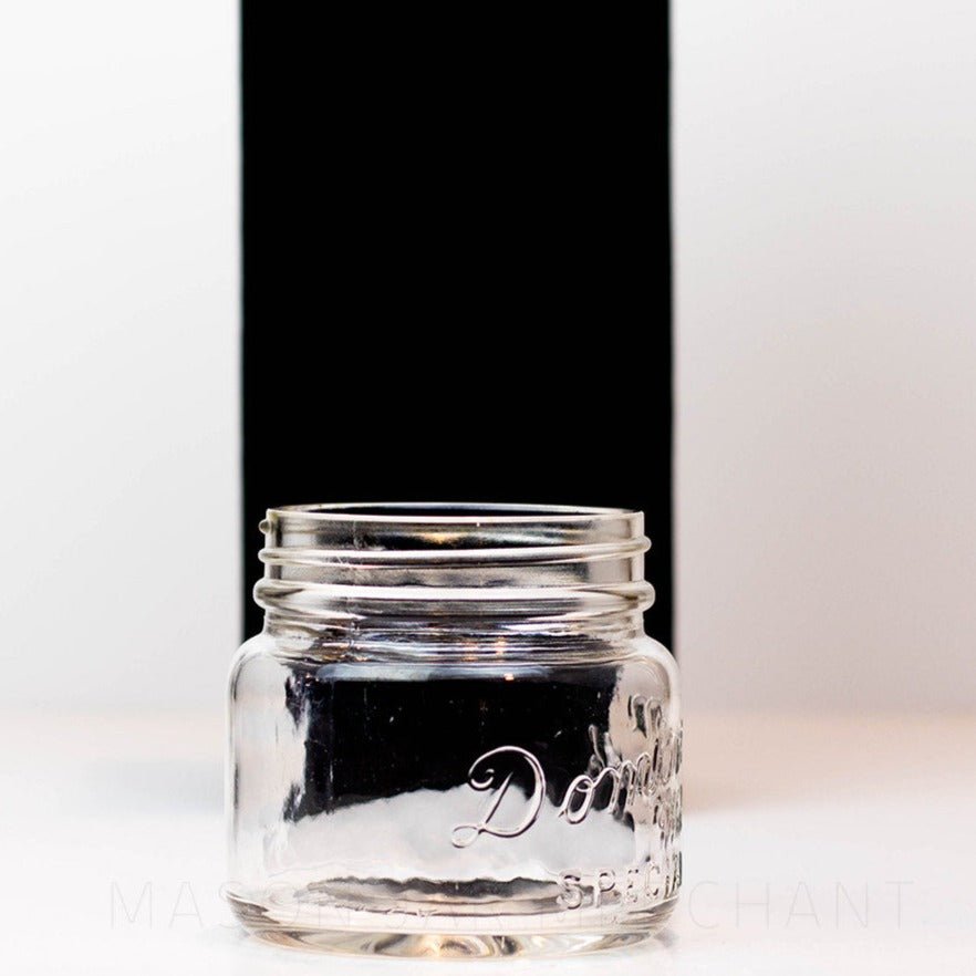 A side view close up of a Vintage wide mouth pint mason jar with Dominion Special logo, against a white background
