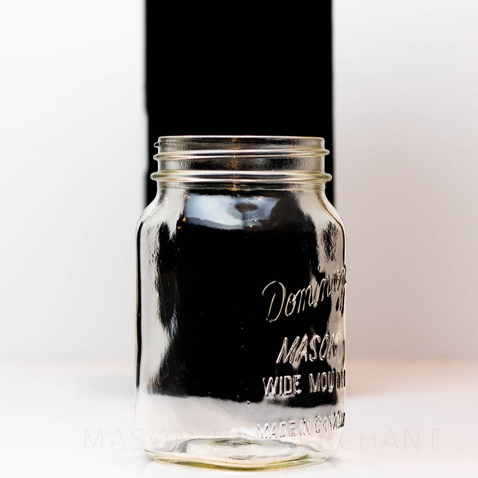 A close up side view of a Wide mouth quart mason jar with Dominion wide mouth Mason logo, against a white background