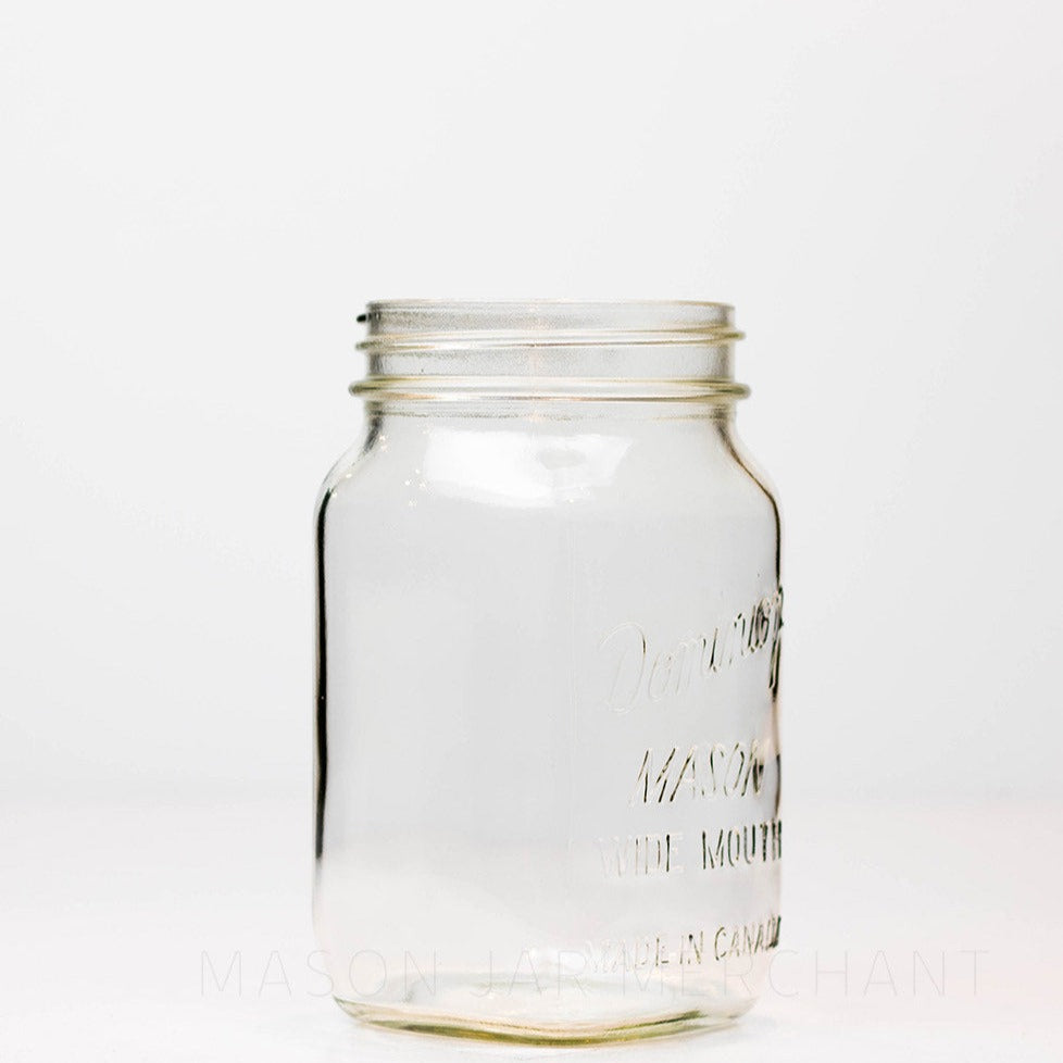 A side view of a Wide mouth quart mason jar with Dominion wide mouth Mason logo, against a white background