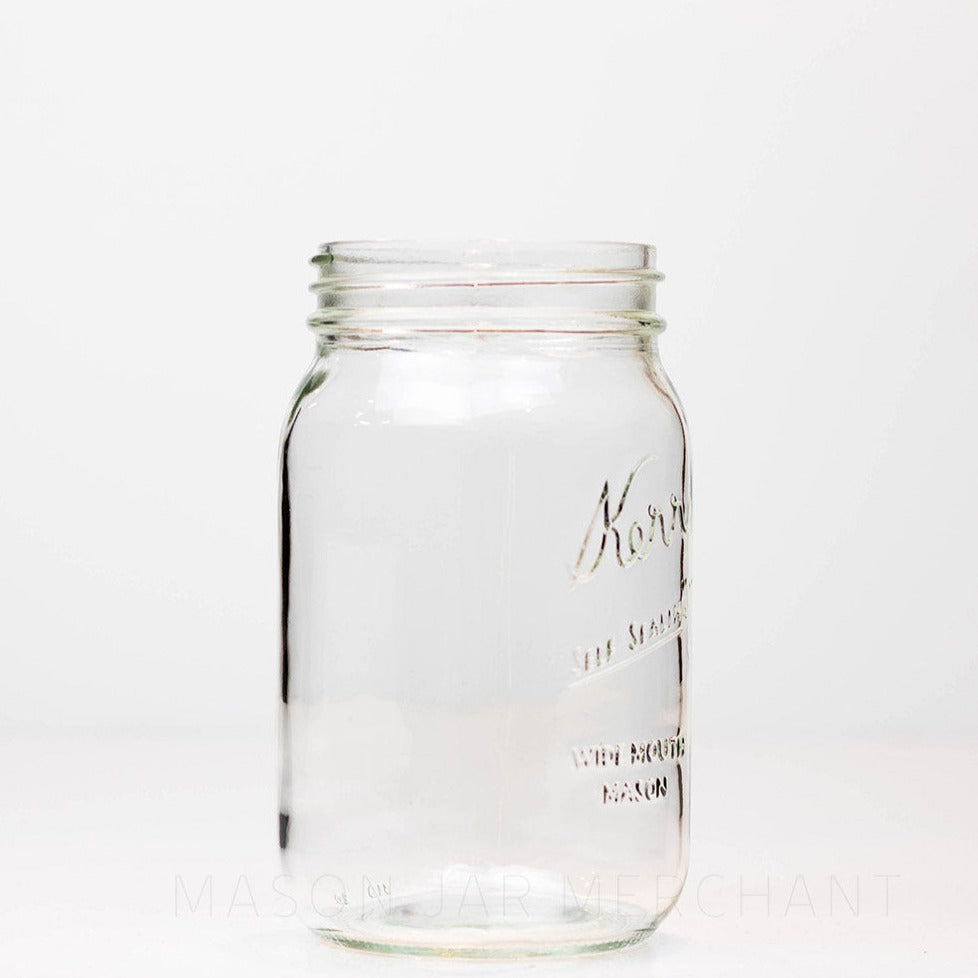 Side view of a wide mouth quart mason jar with Kerr self-sealing logo against a white background