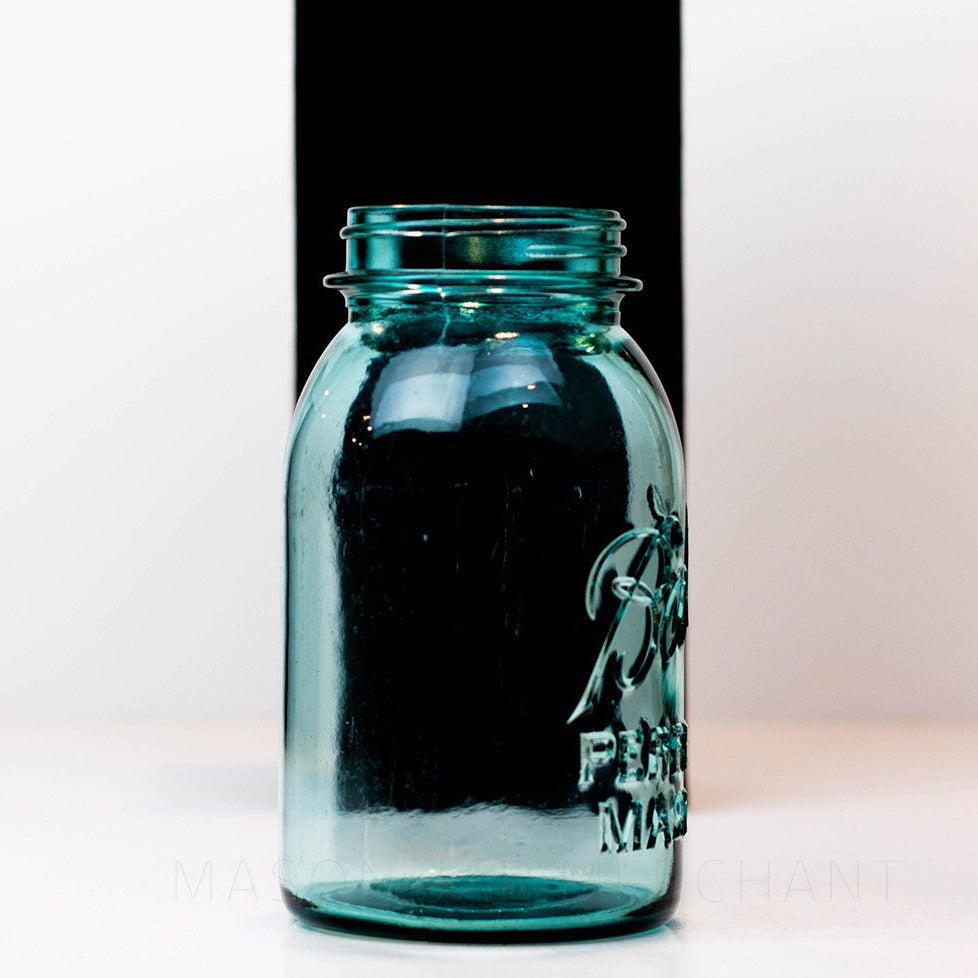 Side view of a Vintage blue Ball regular mouth quart mason jar against a white background