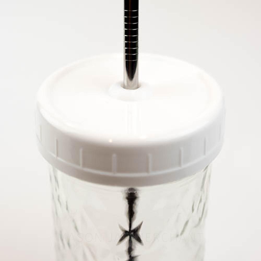 White reugular mouth mason jar straw lid on a mason jar with a stainless steel straw