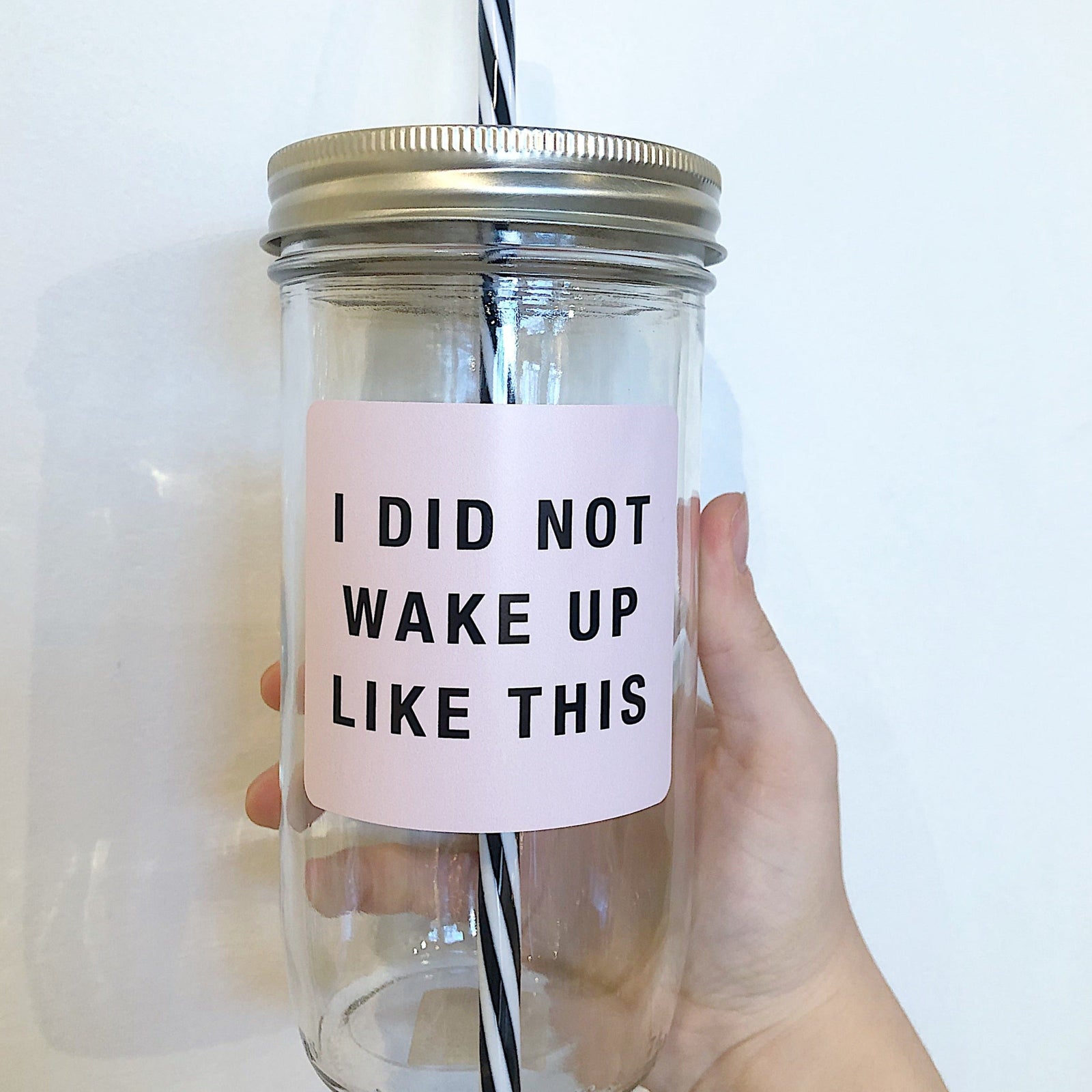 Mason jar tumbler that says "I did not wake up like this” in black on a pink background