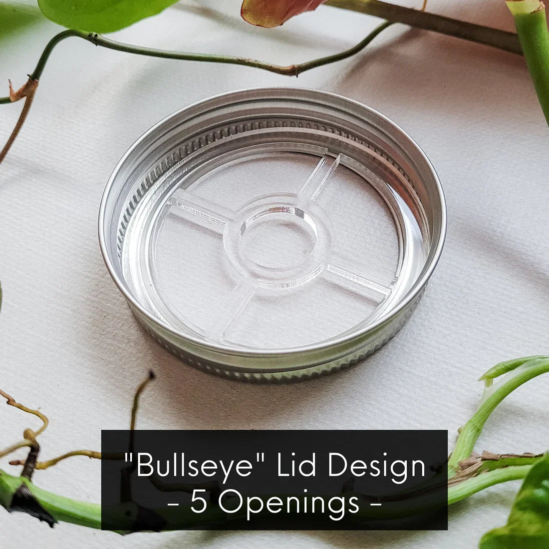 Leaf & Node stainless steel bullseye design mason jar lid insert with 5 openings for plant propagation, on light fabric