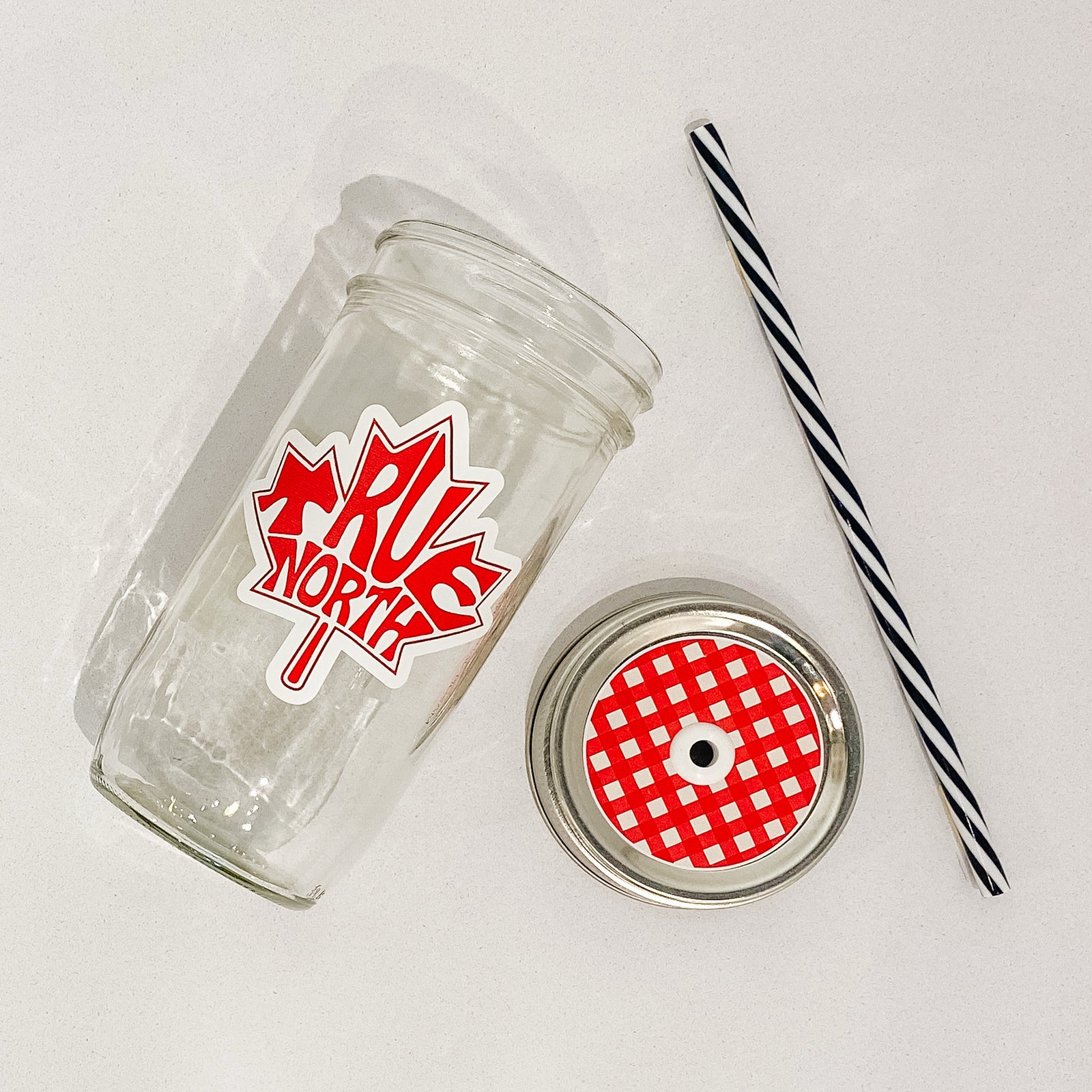 Hand holding mason jar that reads true north in the shape of a maple leaf