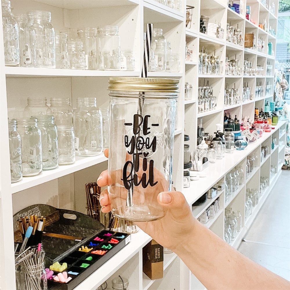 A photo of a mason jar tumbler with a sticker text that says "Be-YOU-ti-ful"
