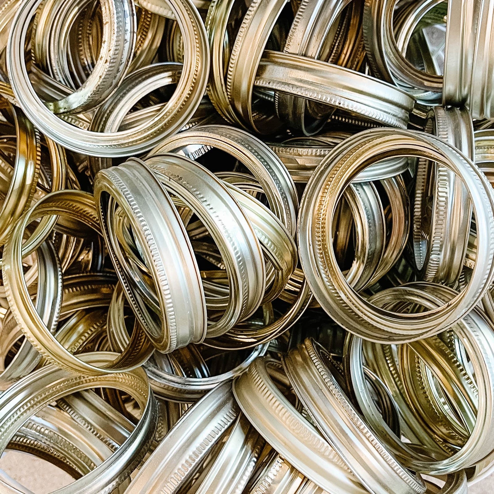 image of gold, wide mouth, mason jar rings. There are small blemishes on the rings