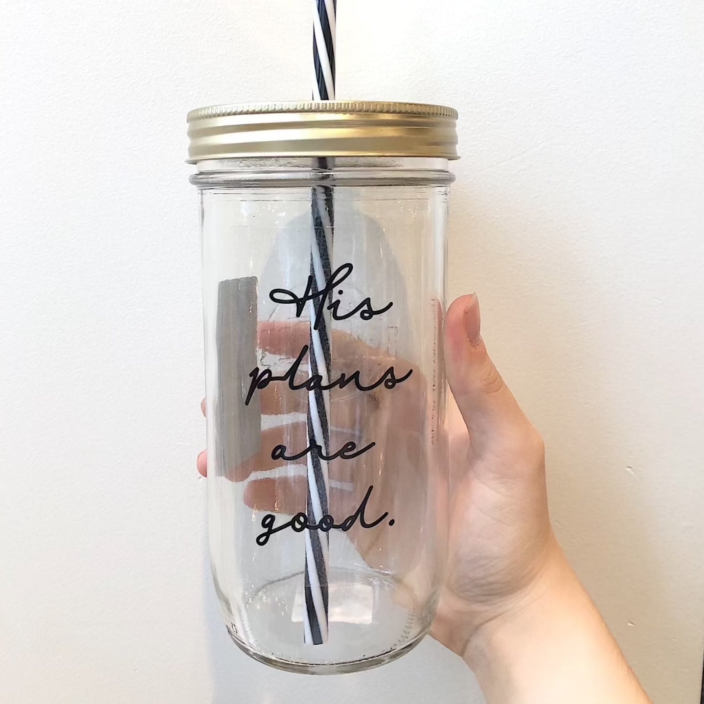 Mason jar tumbler that says “his plans are good” in black script on a clear background