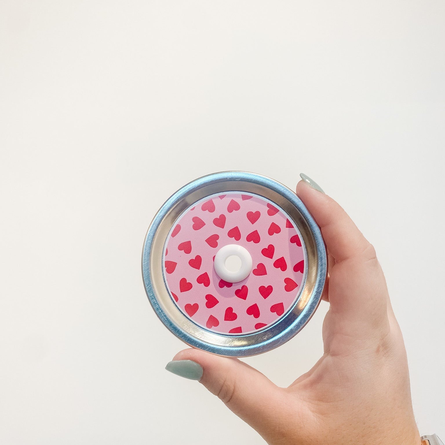 straw lid that has a pink background with red hearts scattered across