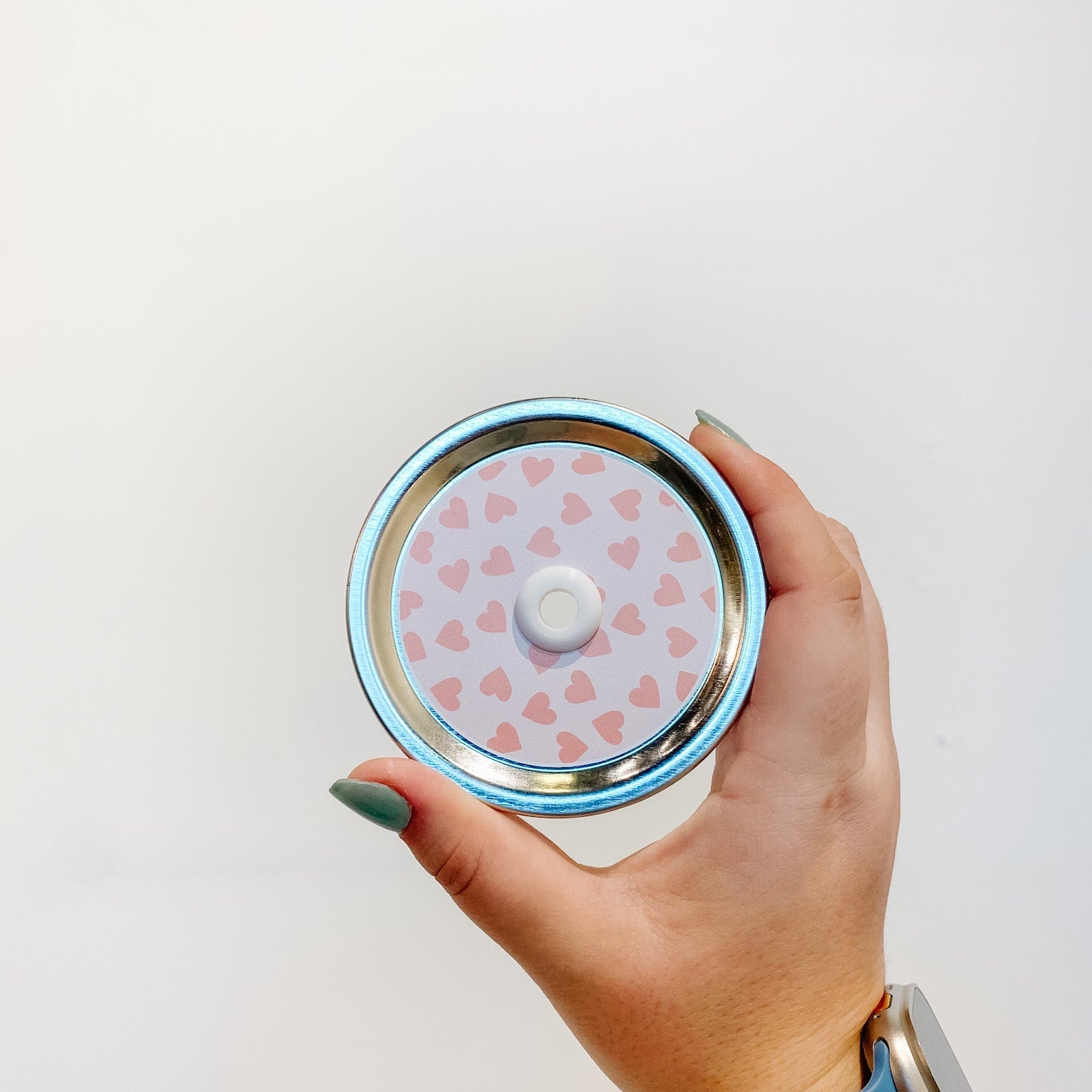 straw lid with a pale pink background and deeper pink hearts scattered across