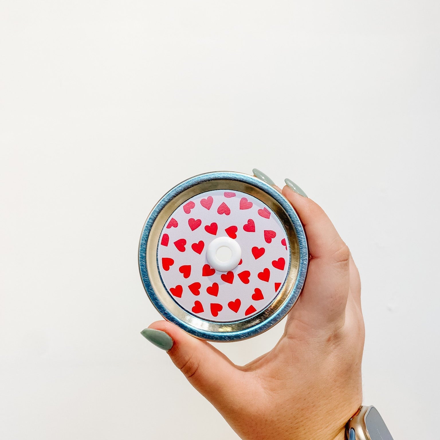 straw lid with a pale pink background and red hearts scattered across