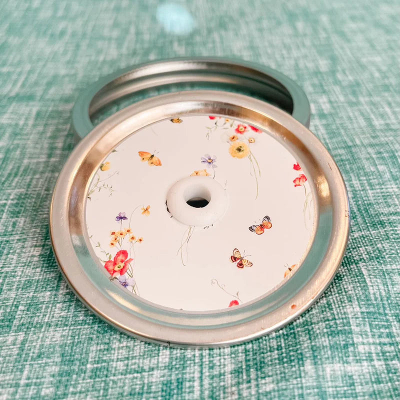 Mason jar patterned straw lid with spaced out and spare assorted flowers and mini butterflies on white 