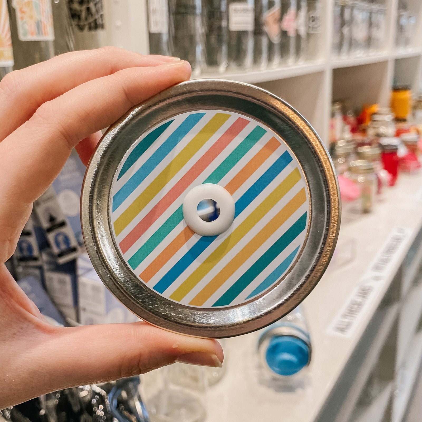 straw lid with coloured lines (blue, green, yellow, orange, and pink) separated by white lines
