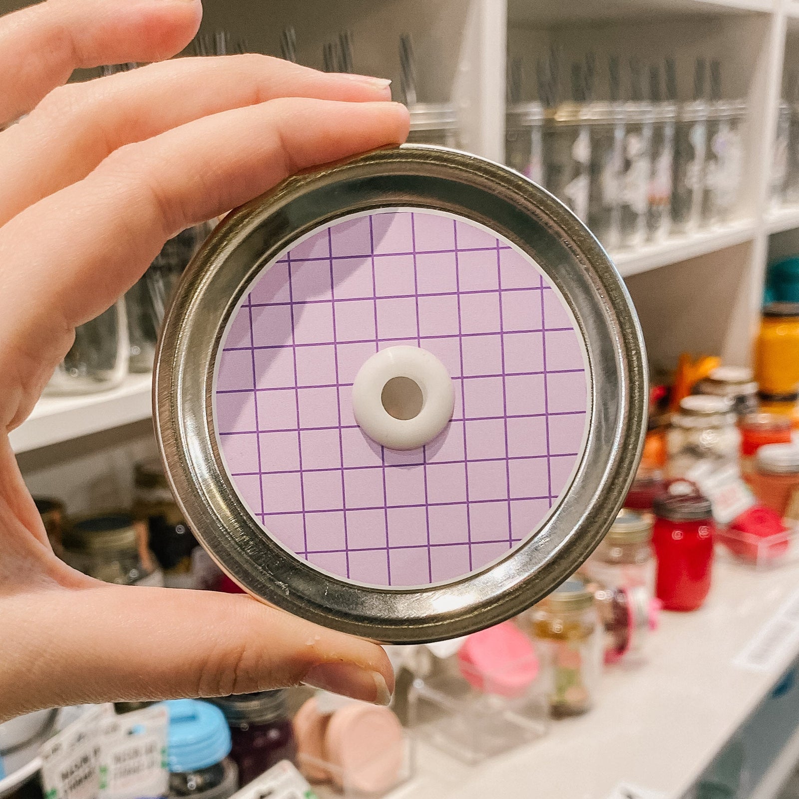 a straw lid that has a pale purple background with a darker purple grid overlayed