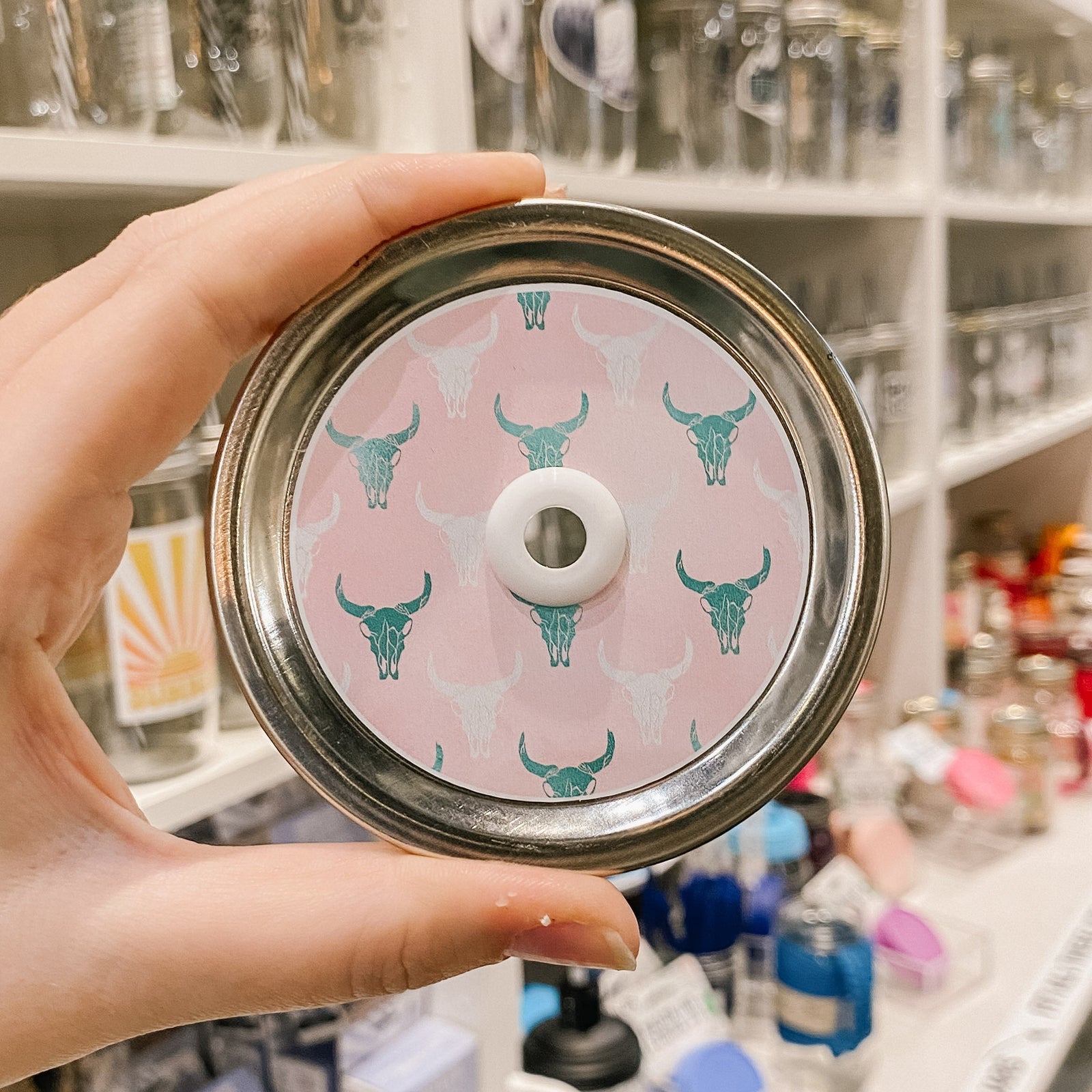 straw lid that has white and green longhorn skulls on a pink background