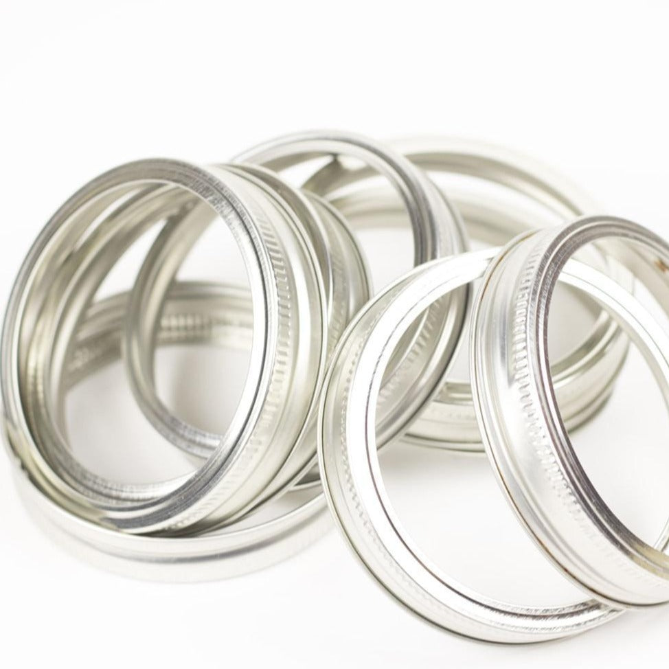 Plain silver wide mouth canning lid against a white background