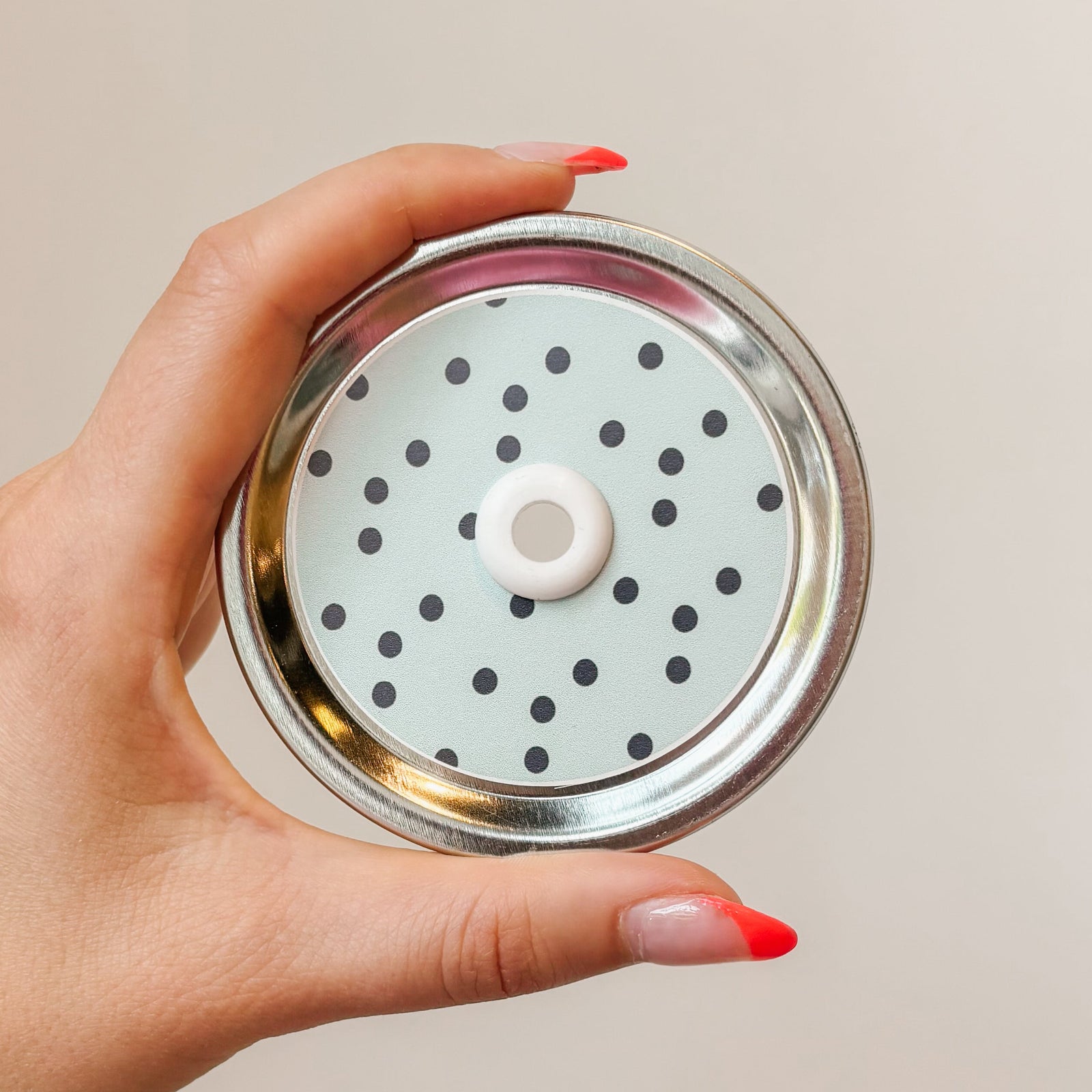 straw lid that has an aqua background with small navy/black polka dots