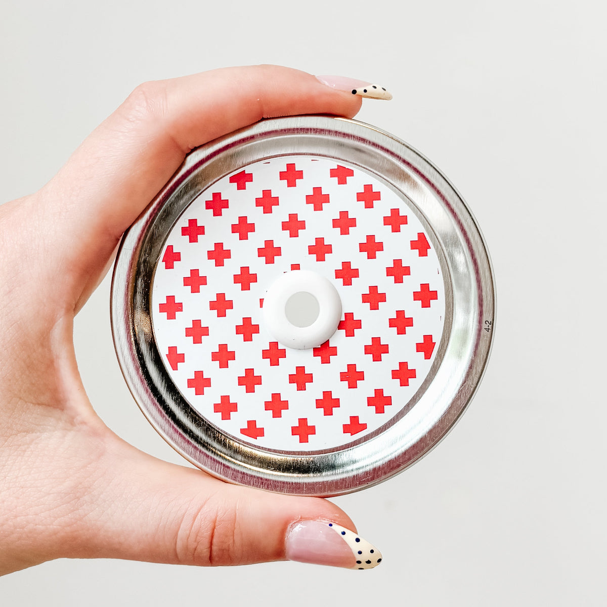 straw lid with a white background and red crosses patterned over the lid