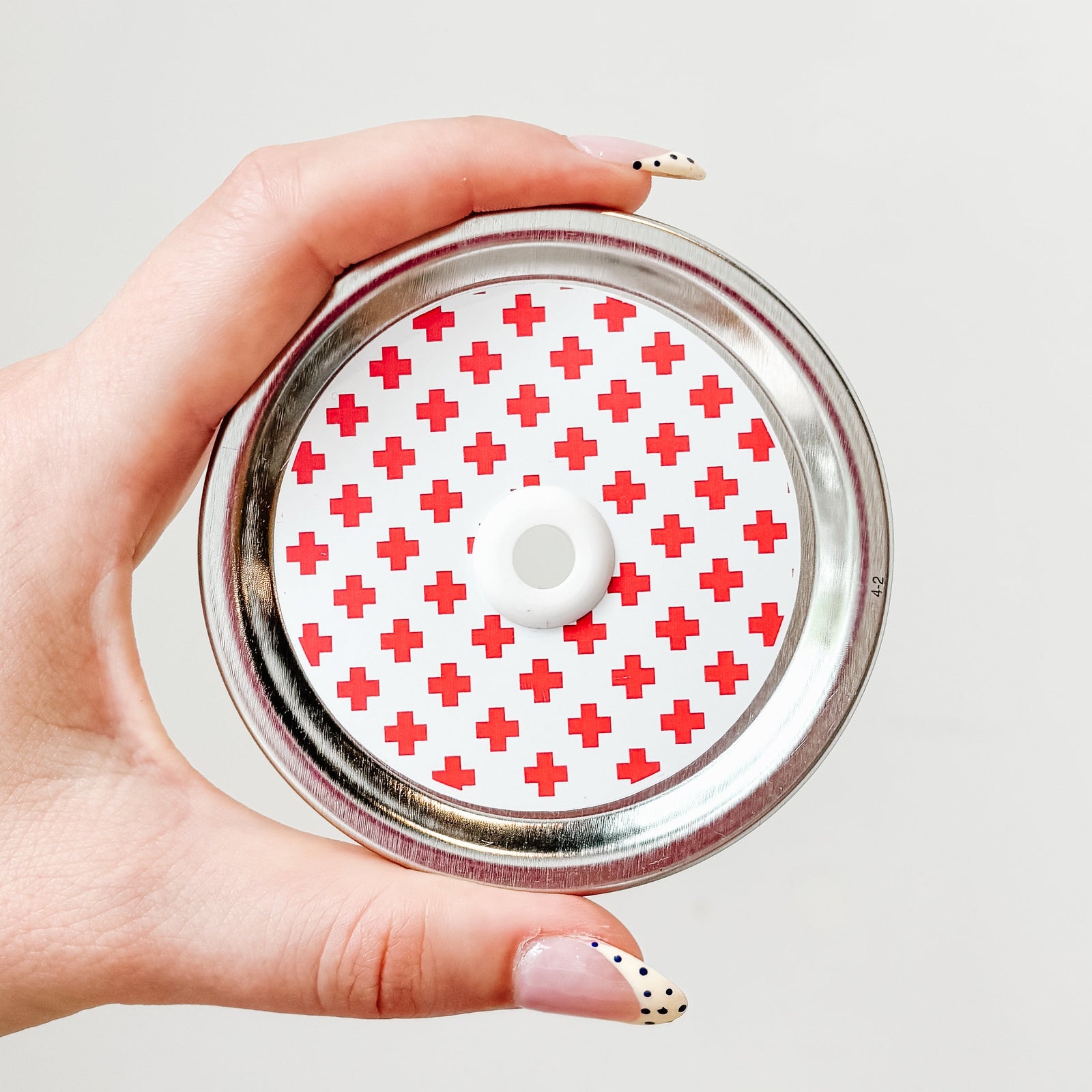 straw lid with a white background and red crosses patterned over the lid