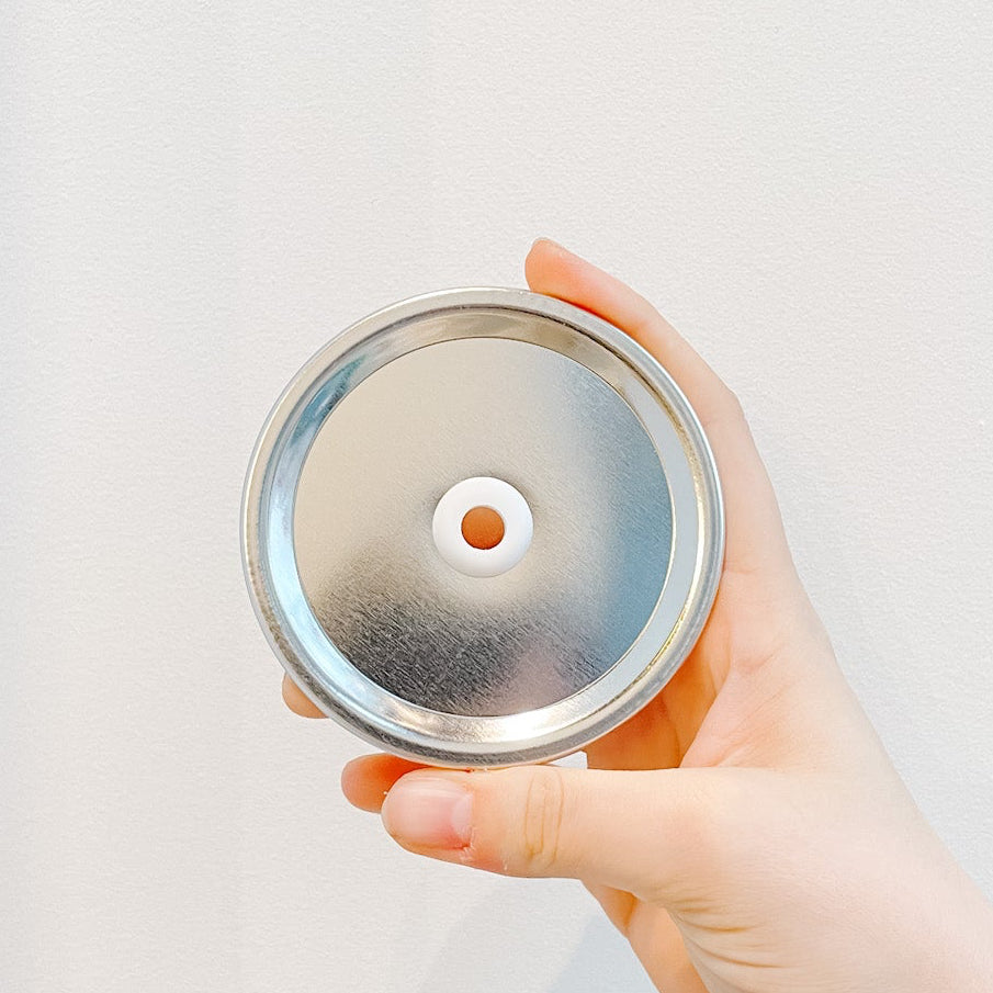 Hand holding a mason jar tumbler with purple multi-tone design including a raccoon and trash can that reads it’s called trash can not trash cannot. Black and white reusable striped straw and silver straw lid. 