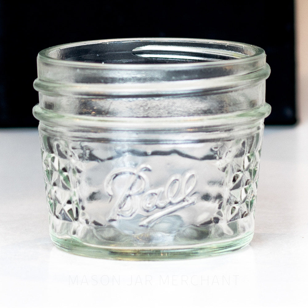 3 oz. regular mouth mason jar with quilted pattern on the sides and a Ball logo on the front, on a white background