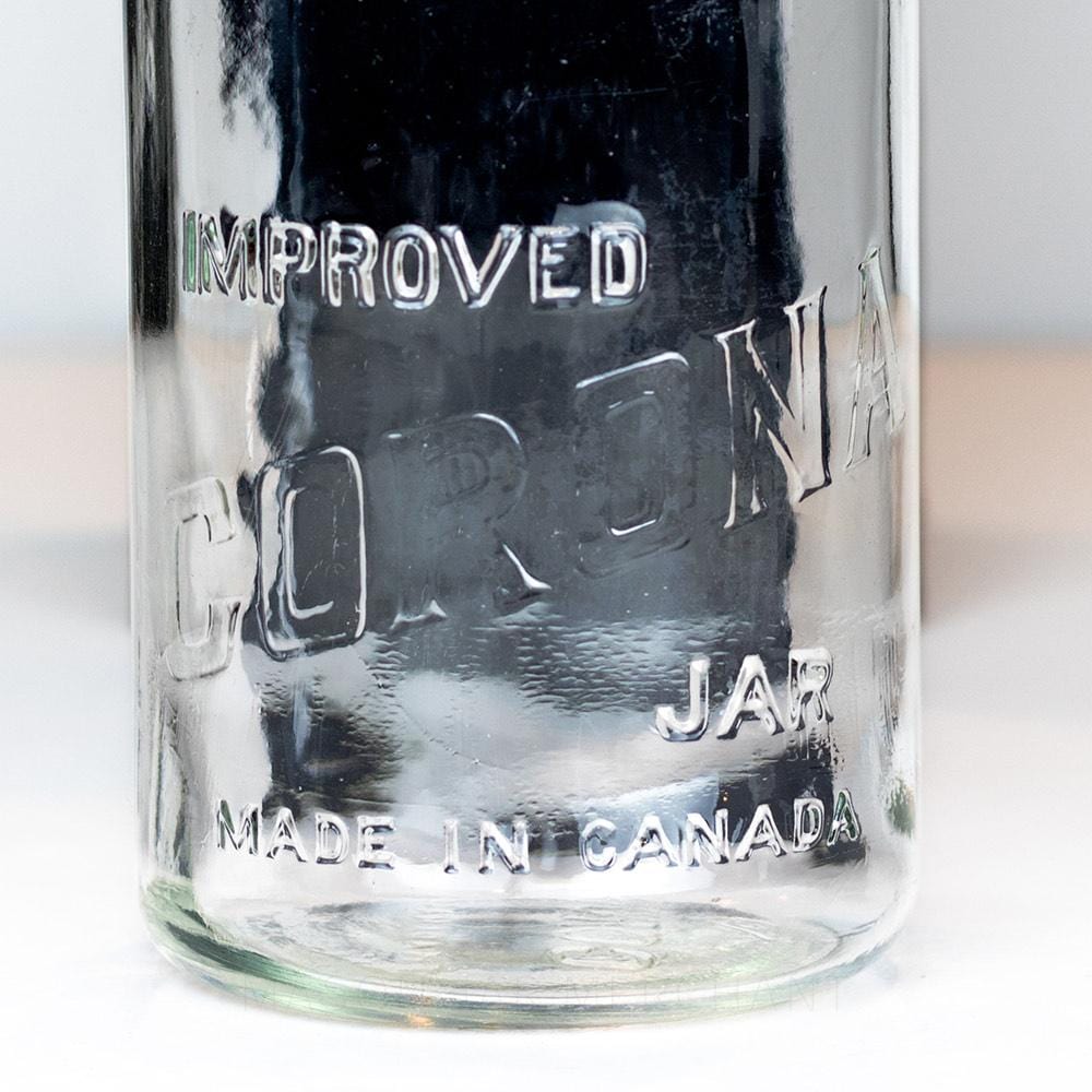 Vintage gem mouth quart mason jar with Improved Corona Jar logo, on a white background