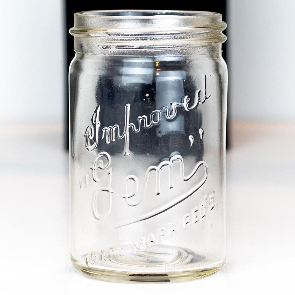 Vintage gem mouth pint mason jar with Improved Gem logo, on a white background