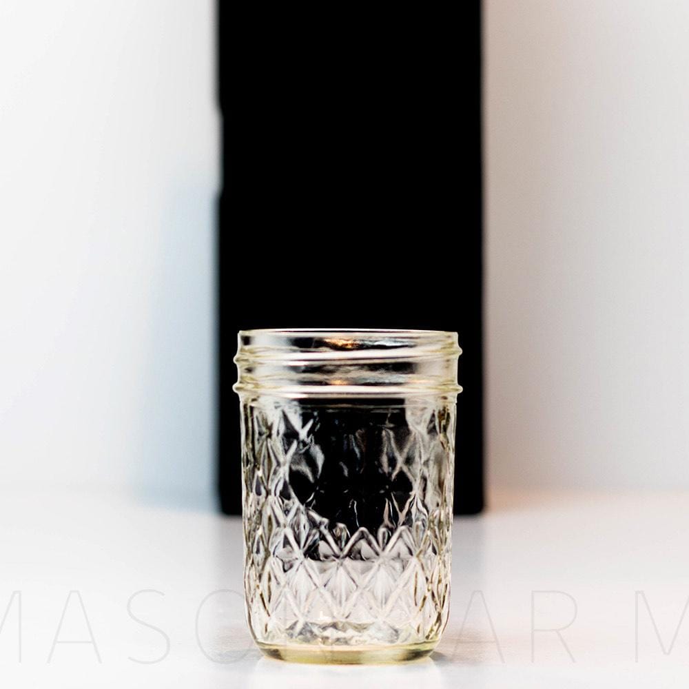 Regular mouth half pint mason jar with a quilted pattern, against a white background