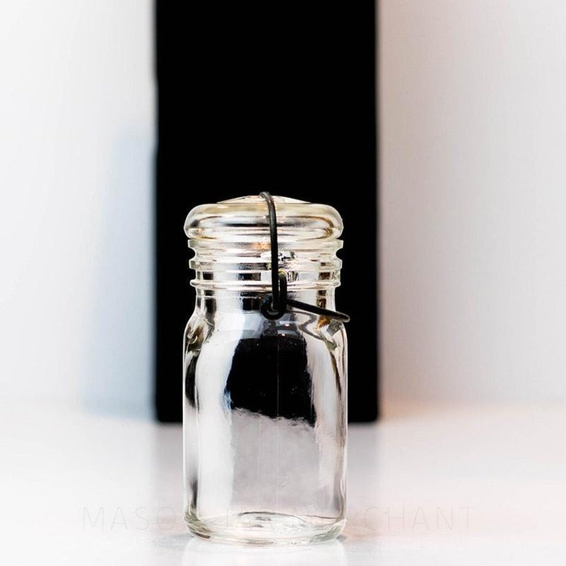 Vintage 1930s half pint wire bail mason jar against a white background