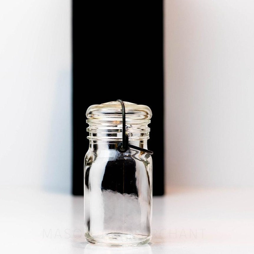 side of a Vintage 1930s half pint wire bail mason jar against a white background