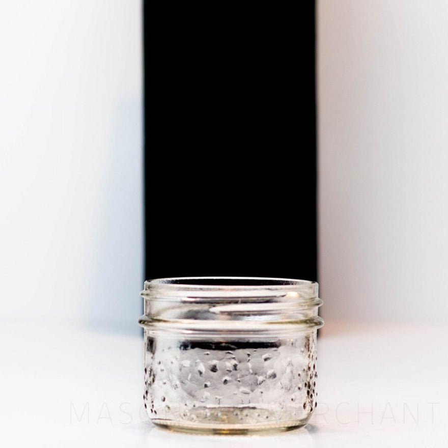 Wide mouth half pint mason jar with a speckled exterior, against a white background