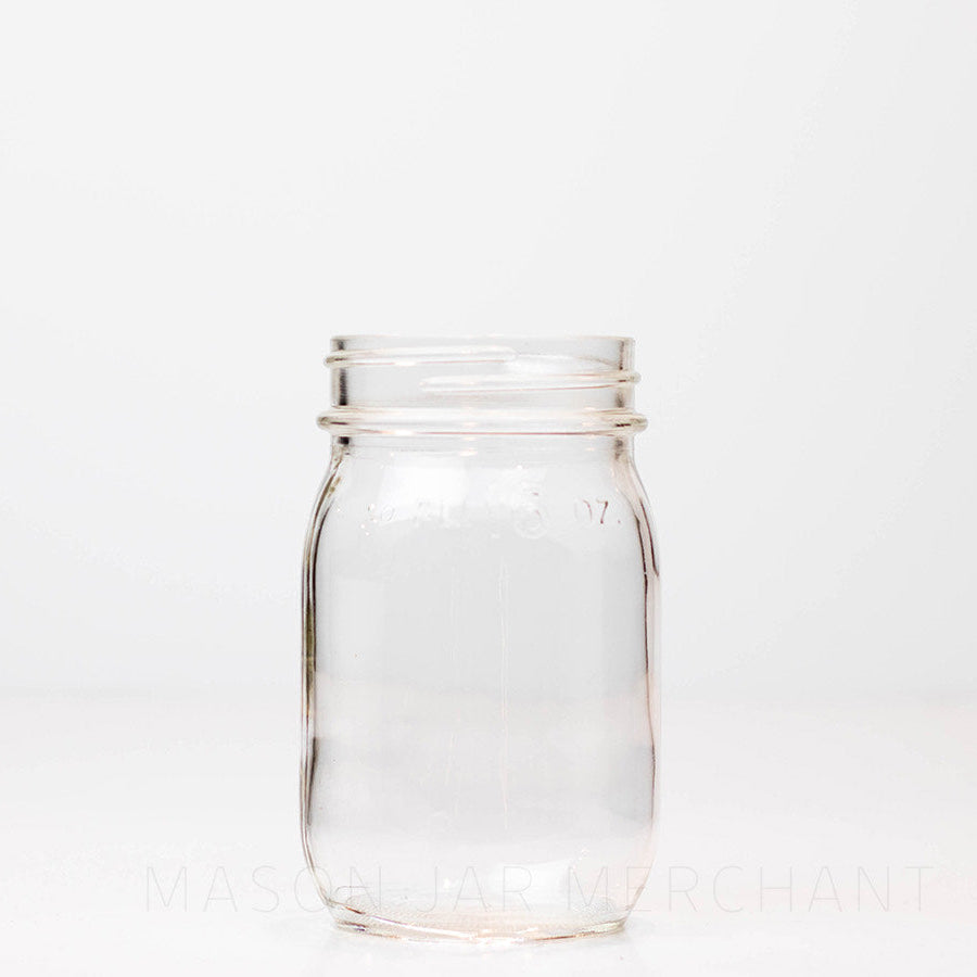 Vintage regular mouth pint mason jar with FL 16 oz imprinted near the rim, against a white background