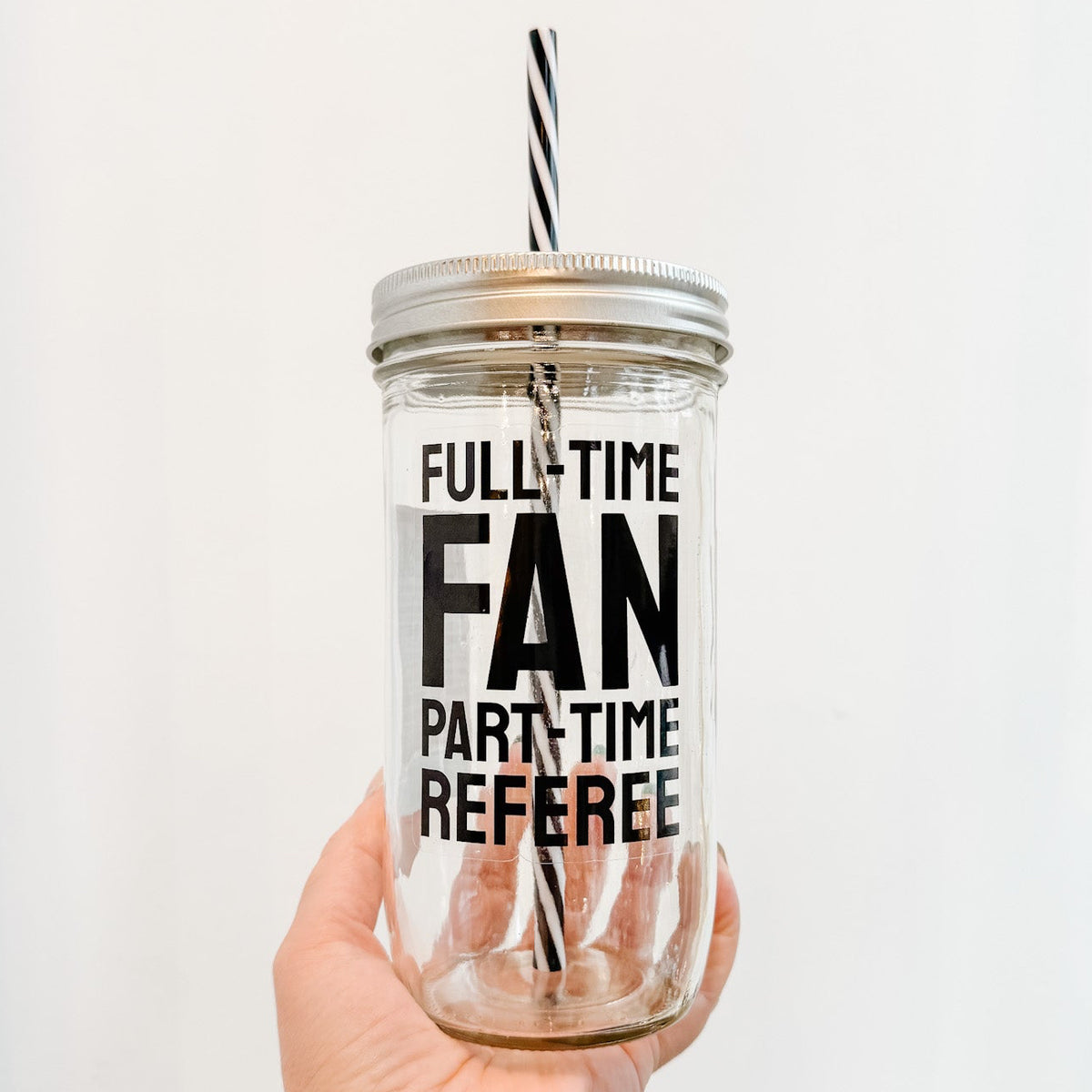 Tumbler with 'Full-Time Fan, Part-Time Referee' text held by a hand against a white background