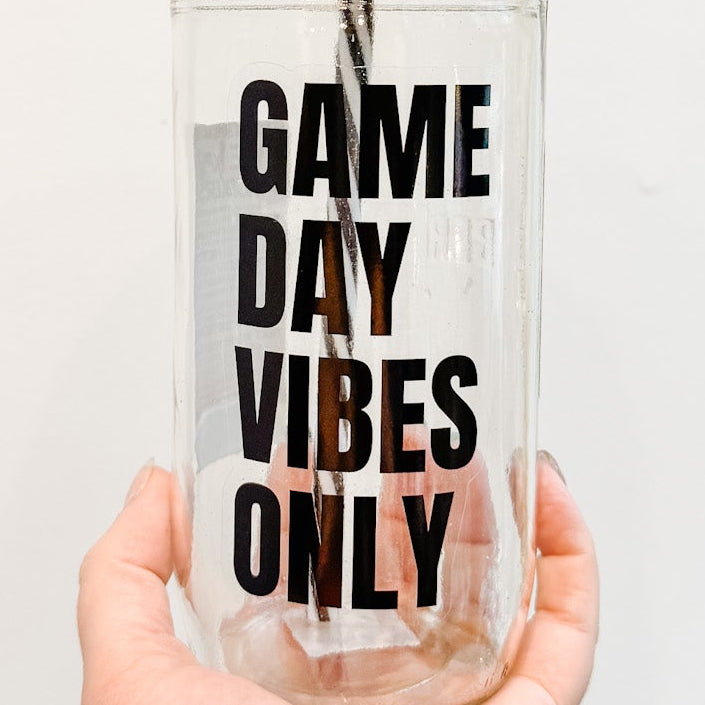 Clear tumbler with 'Game Day Vibes Only' text held by a hand against a white background