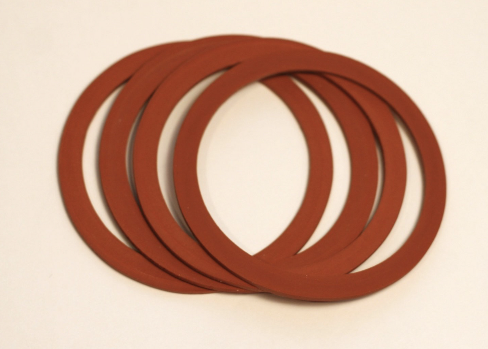 four red GEM mouth rubber seals for mason jars on a white background