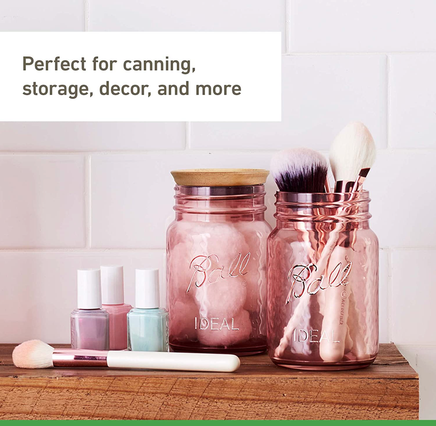 picture of a bathroom shelf with makeup, nail polish, and three mason jars that are a rose pink colour. Each jar has something inside it: a leaf, cotton balls, and makeup brushes