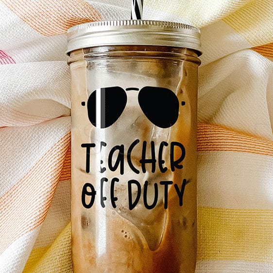 "Teacher Off Duty" print on tumbler with iced coffee with shades above print. Photographed against a striped picnic cloth..