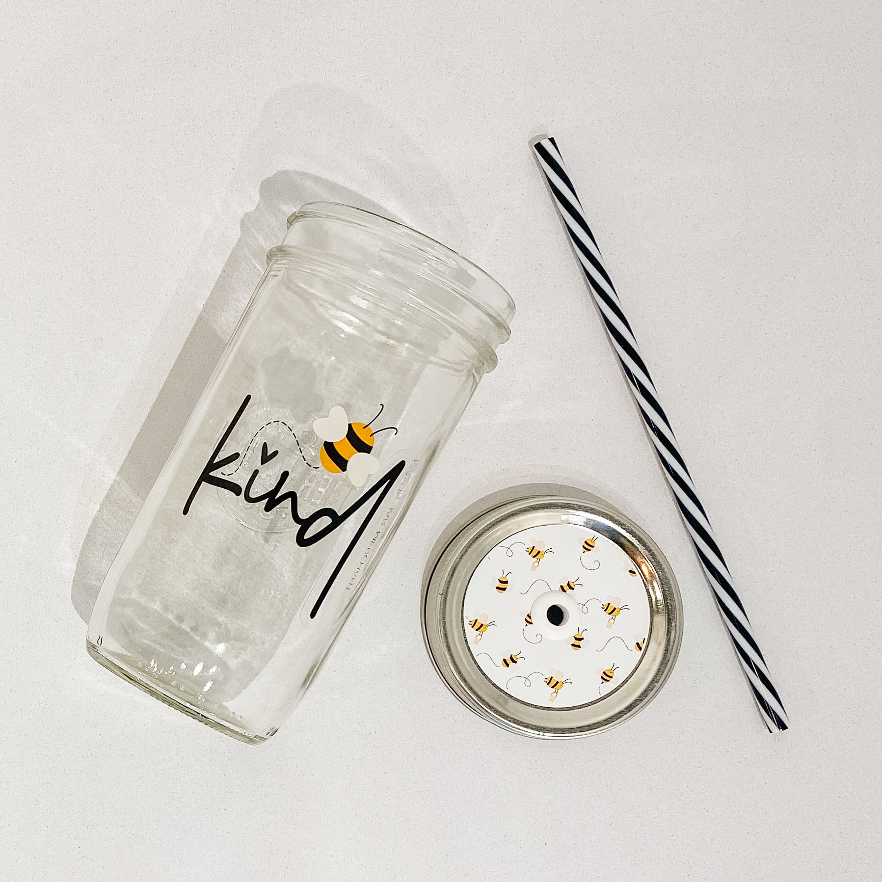 Photo of a mason jar tumbler with print of a bee and a word that says "kind".