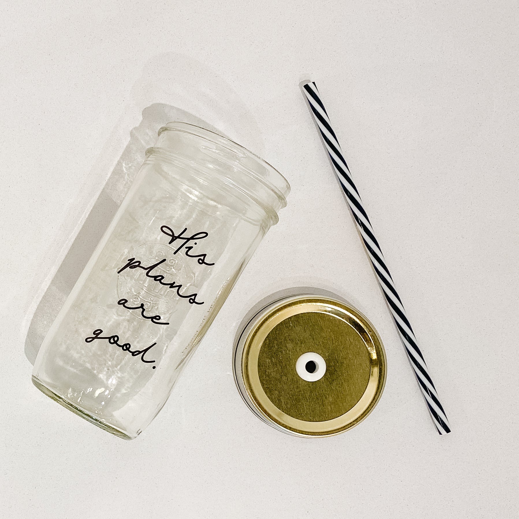 Mason jar tumbler that says “his plans are good” in black script on a clear background