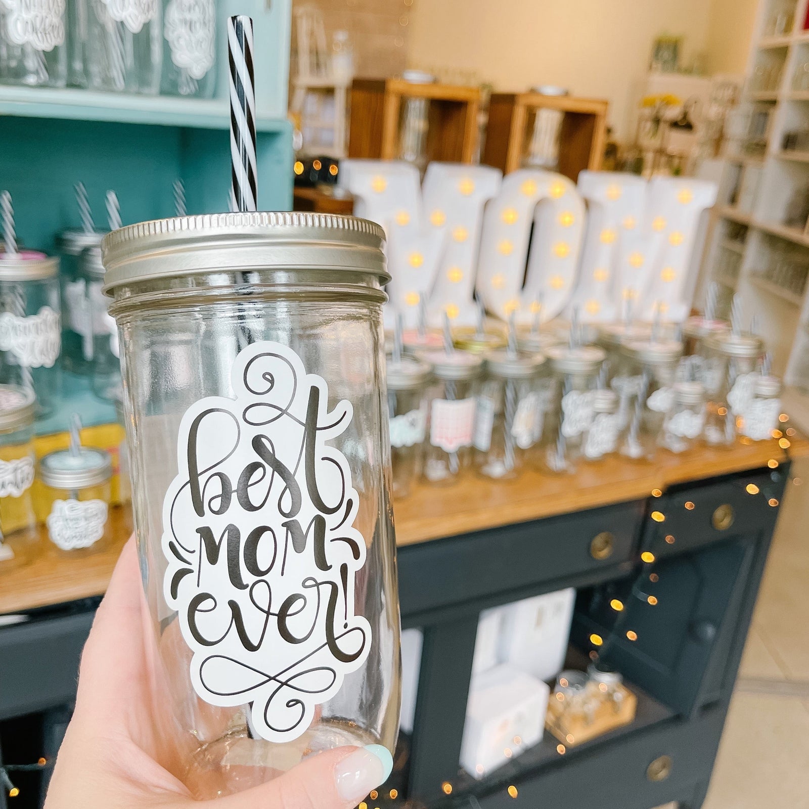 Hand holding a mason jar tumbler that says "best mom ever!”