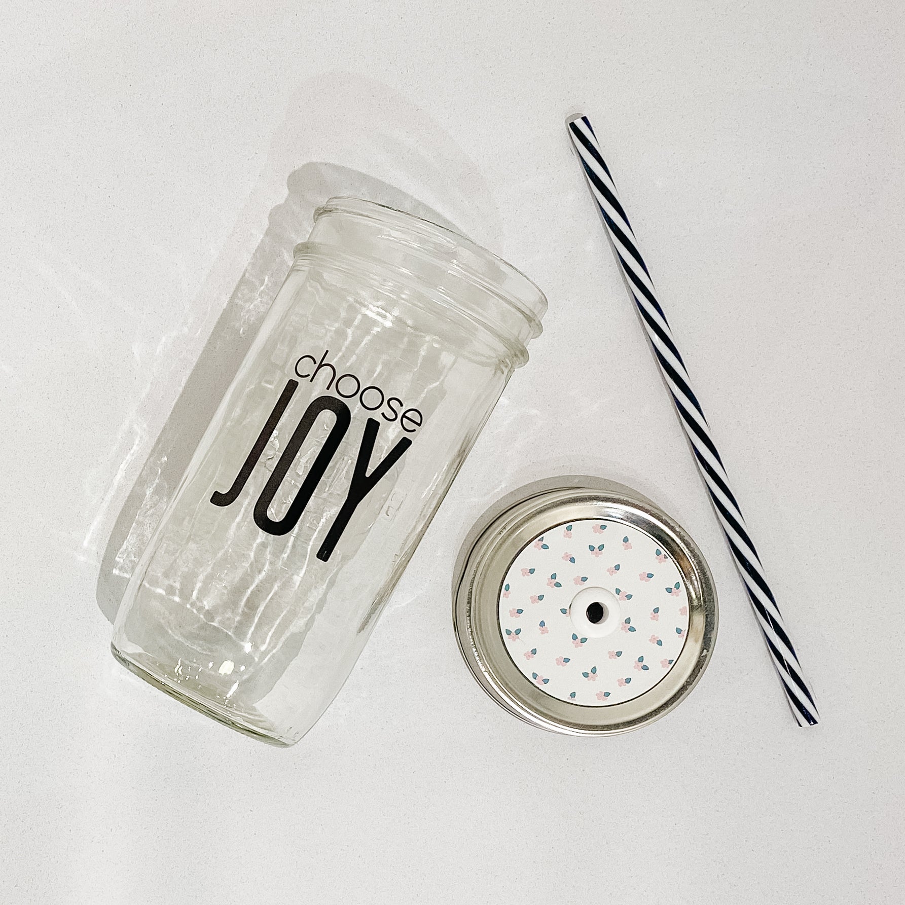 Hand holding a mason jar tumbler that says “choose joy”