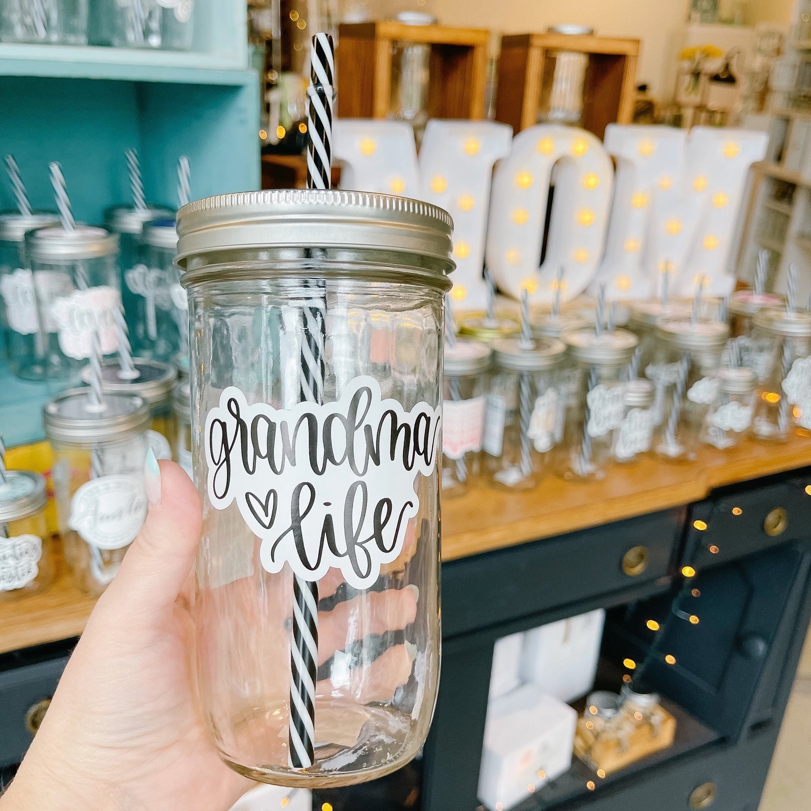 Hand holding a mason jar tumbler that says “grandma life”