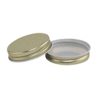two gold mini canning jar lids on a white background
