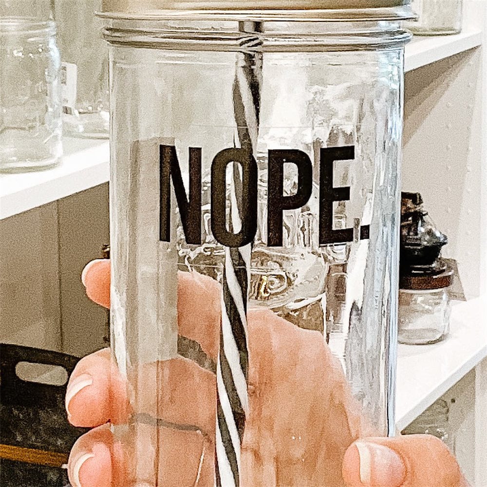 A photo of a mason jar tumbler with a sticker text that says "NOPE"