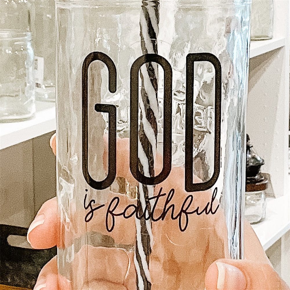 Photo of a mason jar with a print that says God is faithful. It has gold lid and a black and white straw.